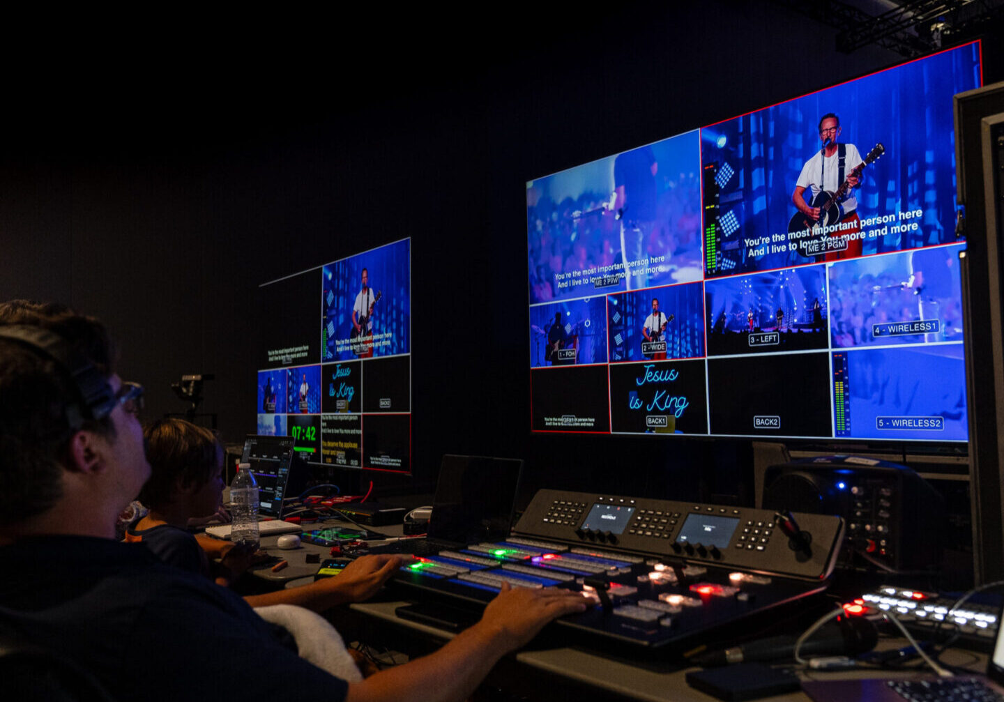 A man is working in front of multiple monitors.