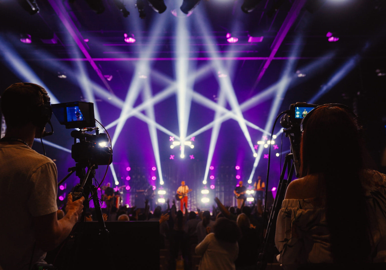 A crowd of people standing in front of lights.