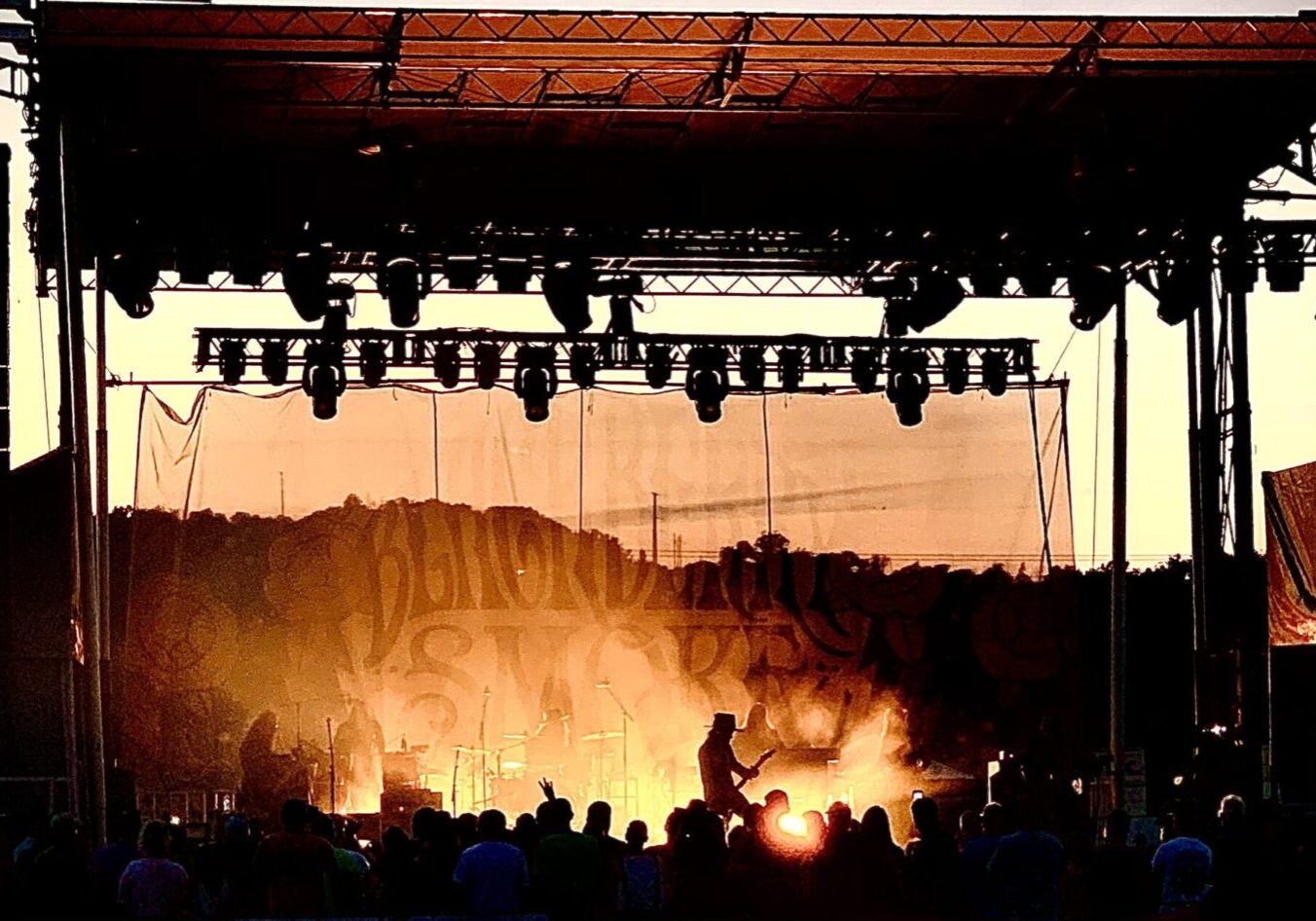 A crowd of people watching an outdoor concert.