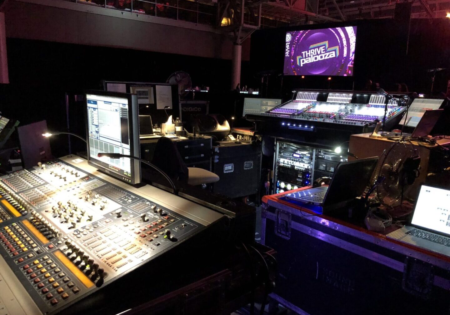 A large sound board in front of a stage.